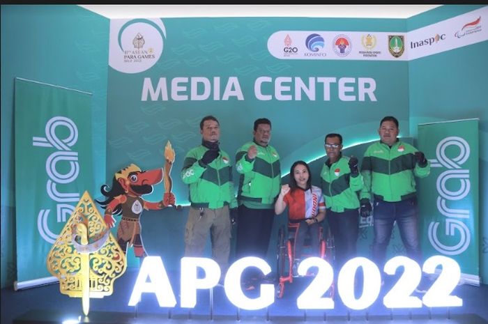 Perwakilan driver Grab yang menjadi sukarelawan ASEAN Para Games 2022 berfoto bersama atlet Para Powerlifting Ni Nengah Widiasih (tengah).