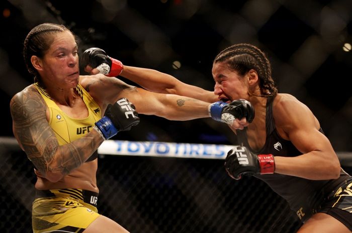 Amanda Nunes (kiri) beradu pukulan dengan Julianna Pena pada laga perebutan gelar kelas bantam wanita pada UFC 277 yang digelar di American Airlines Center, Texas, Amerika Serikat, 30 Juli 2022. Nunes menang dengan keputusan angka mutlak untuk merebut kembali sabuk juara kelas bantam.