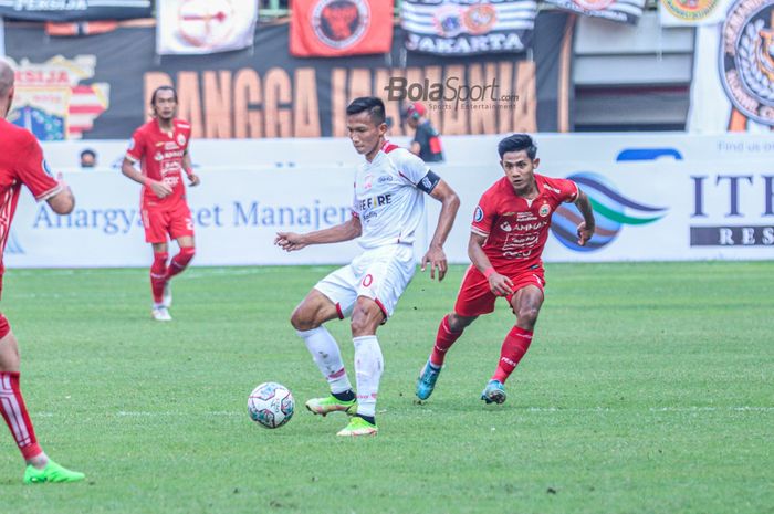 Bek Persis Solo, Eky Taufik (kiri), sedang menguasai bola dan dibayangi pemain Persija Jakarta bernama Firza Andika (kanan) saat bertanding di Stadion Patriot Candrabhaga, Bekasi, Jawa Barat, 31 Juli 2022.
