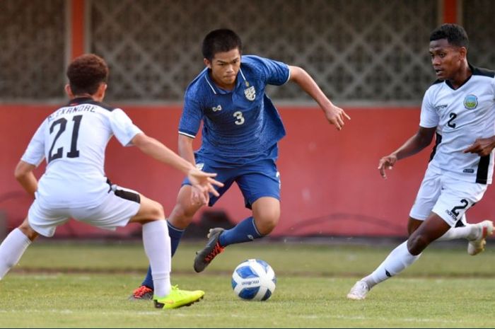 Pemain Timnas U-16 Thailand diapit oleh dua pemain Timnas U-16 Timor Leste pada laga Grup B Piala AFF U-16 2022, Minggu (7/8/2022).