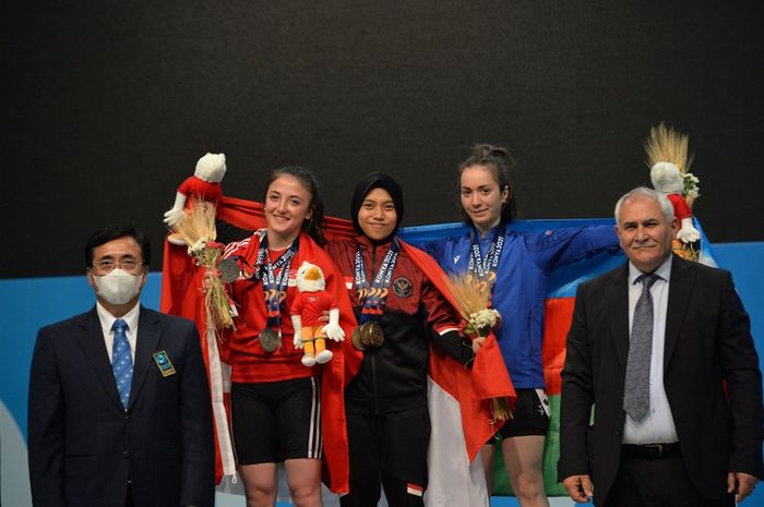 Lifter putri Indonesia, Siti Nafisatul  Hariroh, berpose di podium juara setelah merebut 3 medali emas di kelas 45 kg cabang angkat besi di Konya, Turki, Kamis (11/8/2022) waktu setempat.