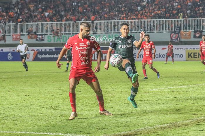 Pemain Persikabo 1973, Roni Sugeng Ariyanto (kanan), sedang menghalau bola yang dikuasai penyerang Persija Jakarta bernama Abdulla Yusuf Abdulrahim Mohamed Helal (kiri) Striker Persija Jakarta, Abdulla Yusuf Abdulrahim Mohamed Helal (kanan), sedang berduel udara menyundul bola dalam laga pekan keemp