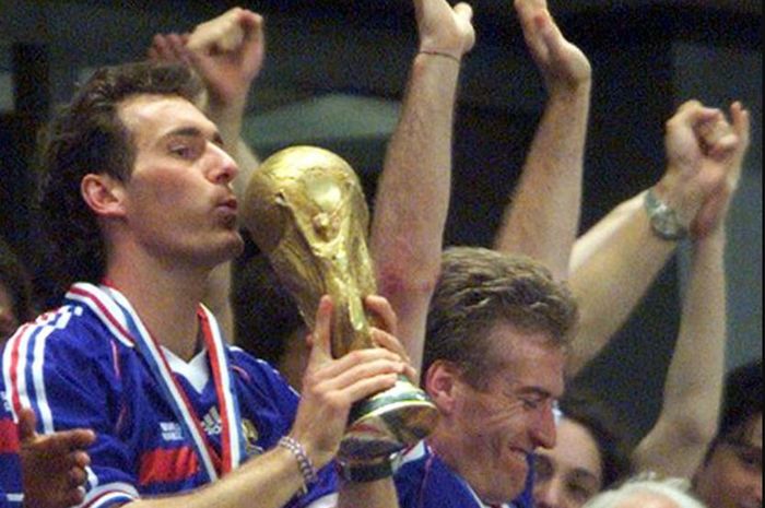 Laurent Blanc tengah mencium trofi Piala Dunia 1998 yang berhasil ia dapatkan bersama Timnas Prancis.
