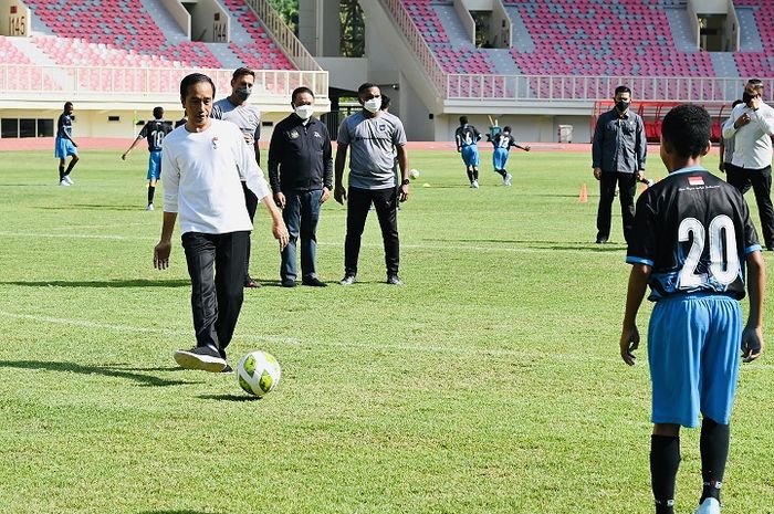 Presiden Joko Widodo menendang bola ketika resmi meluncurkan Papua Football Academy (PFA) di Stadion Lukas Enembe, Sentani, Papua, Rabu (31/8/2022).