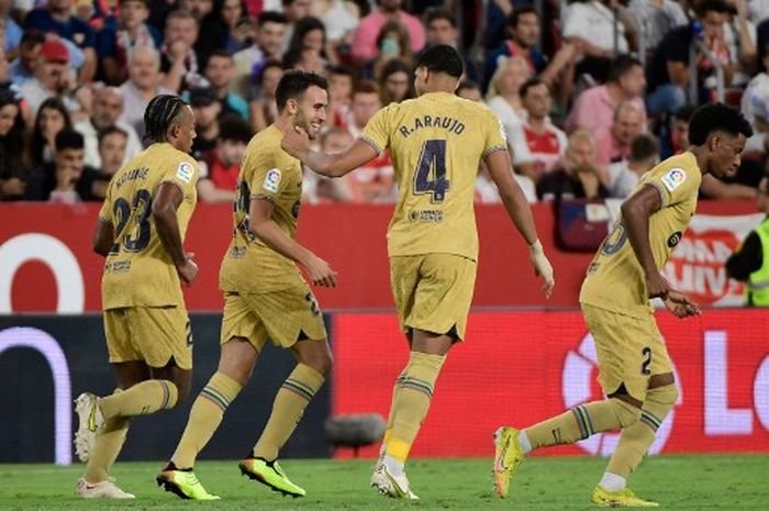 Barcelona's Spanish forward Eric Garcia (2nd-L) celebrates with Barcelona's French defender Jules Kounde (L) and Barcelona's Uruguayan defender Ronald Araujo after scoring his team's third goal during the Spanish league football match between Sevilla FC and FC Barcelona at the Ramon Sanchez Pizjuan 