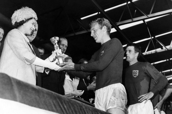 Ratu Elizabeth II menyerahkan trofi juara Piala Dunia 1966 kepada kapten timnas Inggris, Bobby Moore (30/7/1966).