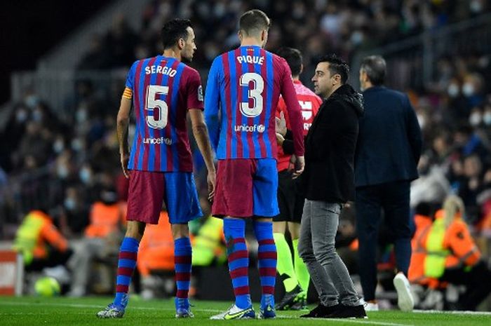 Xavi berbicara dengan Sergio Busquets dan Gerard Pique dalam laga Barcelona vs Espanyol di Camp Nou (20/11/2021).