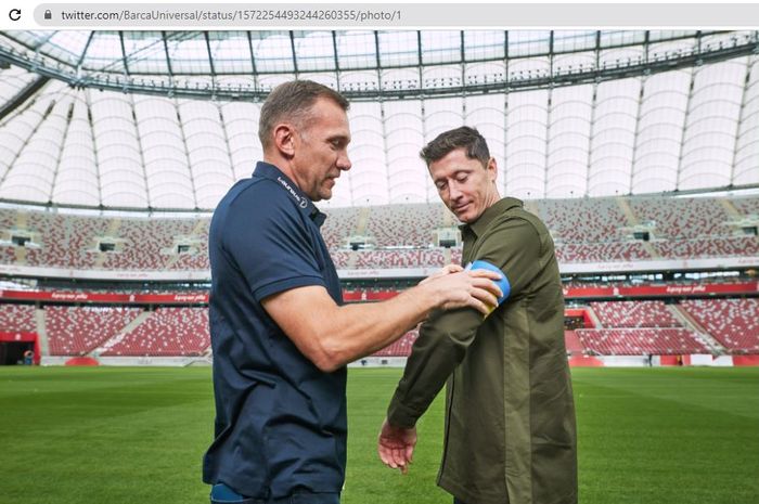 Andriy Shevchenko (kiri) memasangkan ban kapten bergambar bendera Ukraina ke lengan Robert Lewandowski (kanan) yang akan digunakan pada Piala Dunia 2022 nanti.