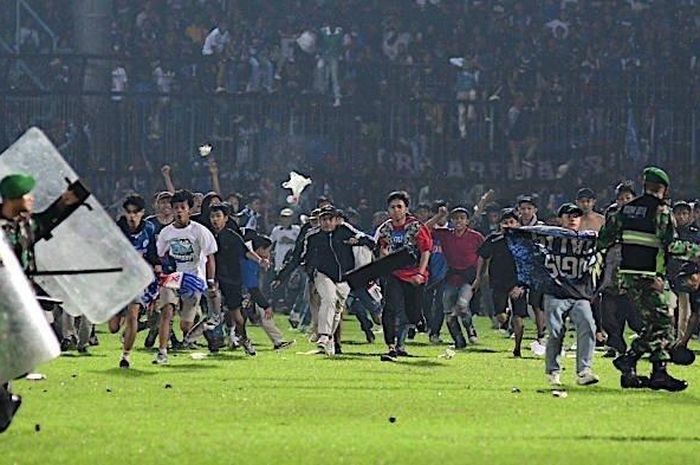 Suporter Arema FC, Aremania menerobos ke dalam lapangan usai Arema FC dikalahkan Persebaya Surabaya dengan skor 2-3 dalam laga lanjutan Liga 1 2022 di Stadion Kanjuruhan, Malang, Sabtu (1/10/2022).  