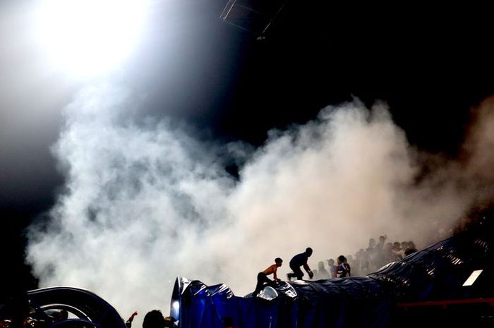 Asap gas air mata menyelimuti area Stadion Kanjuruhan, Kepanjen, Kabupaten Malang, menyusul kericuhan penonton yang terjadi seusai laga pekan ke-11 Liga 1 2022-2023 bertajuk derbi Jawa Timur, Arema FC vs Persebaya Surabaya, Sabtu (1/10/2022) malam.