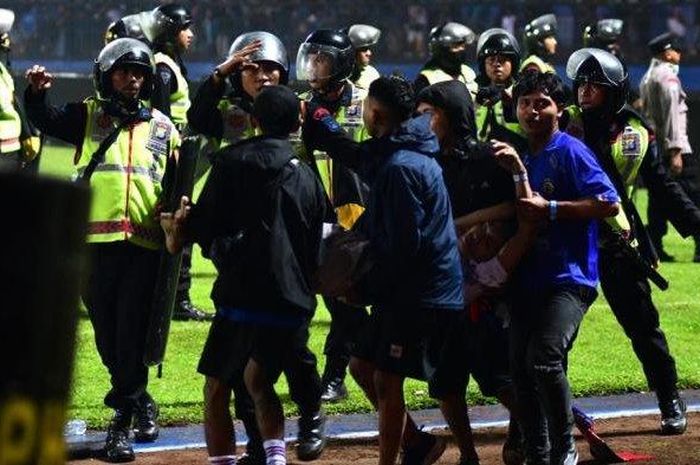 Aremania membopong korban kericuhan saat laga Arema FC vs Persebaya Surabaya di Stadion Kanjuruhan, Kabupaten Malang, Sabtu (1/10/2022). 