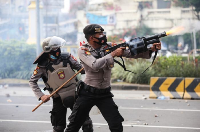 Polisi menembakkan gas air mata dalam unjuk rasa UU Cipta Kerja di kawasan Istana Negara, Jakarta, 8 Oktober 2022. Gas air mata mewarnai tragedi di Stadion Kanjuruhan, Malang, Sabtu (1/10/2022) malam.