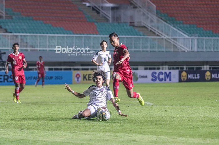 Pemain timnas U-17 Indonesia sedang menguasai bola dan berusaha ditekel pilar timnas U-17 Guam bernama Brenden Tim Tuey (kanan) dalam laga pekan pertama grup B Kualifikasi Piala Asia U-17 2023 di Stadion Pakansari, Bogor, Jawa Barat, 3 Oktober 2022.
