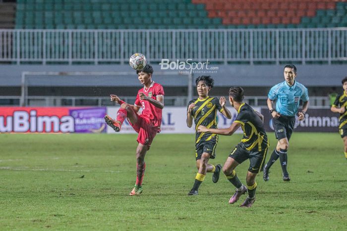 Pemain timnas U-17 Indonesia, Arkhan Kaka Putra (kiri), sedang menendang dan dikawal pilar timnas U-17 Malaysia bernama Muhammad Afiq Danish (tengah) dalam laga Kualifikasi Piala Asia U-17 2023 di Stadion Pakansari, Bogor, Jawa Barat, 9 Oktober 2022.