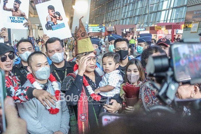 Petarung MMA asal Indonesia, Jeka Saragih (tengah) sedang menggendong sang anak bernama Jansen Saragih (kiri) dan istrinya yakni Destia Uliana Siahaan di Terminal 3 Bandara Soekarno Hatta, Tangerang, Banten, 25 Oktober 2022.