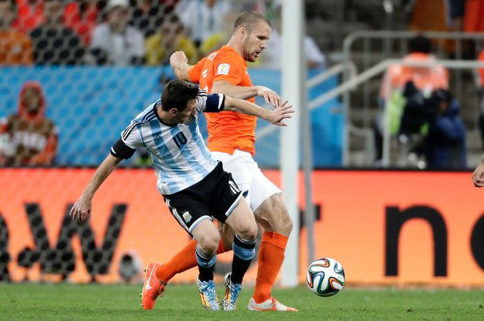 Pemain timnas Belanda, Ron Vlaar. saat berduel dengan penyerang timnas Argentina, Lionel Messi, dalam partai semifinal Piala Dunia 2014.