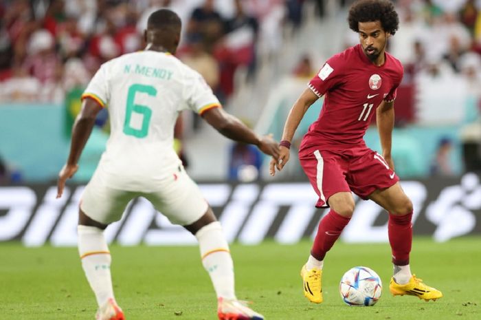 Striker Timnas Qatar Akram Afif (kanan) kesulitan melewati pemain Senegal dalam Piala Dunia 2022.
