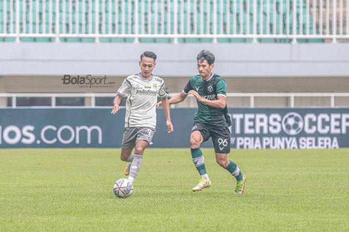 Gelandang Persib Bandung, Beckham Putra Nugraha (kiri), tampak sedang menguasai bola dan dibayangi pemain Persikabo 1973 bernama Rian Kurnia (kanan) dalam laga uji coba di Stadion Pakansari, Bogor, Jawa Barat, 27 November 2022.