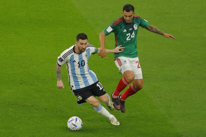 Striker timnas Argentina, Lionel Messi, berduel dengan gelandang timnas Meksiko, Luis Chavez, dalam laga Grup C Piala Dunia 2022 di Stadion Lusail, Sabtu (26/11/2022).