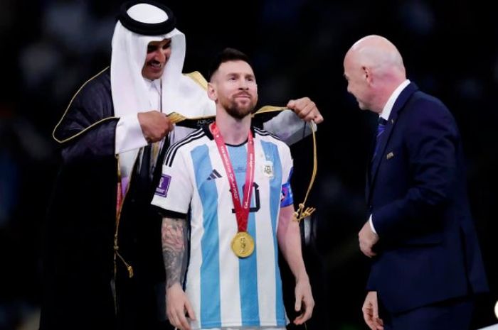 Emir Qatar, Tamim bin Hamad Al-Thani, memakaikan jubah bisht untuk kapten Timnas Argentina, Lionel Messi.