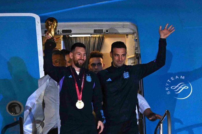 Lionel Messi dan Lionel Scaloni saat tiba di Bandara Ezeiza dengan trofi Piala Dunia 2022 untuk timnas Argentina. Scaloni menilai di mana pun Messi bermain usai cerai dengan PSG tak masalah, asalkan dia bahagia.