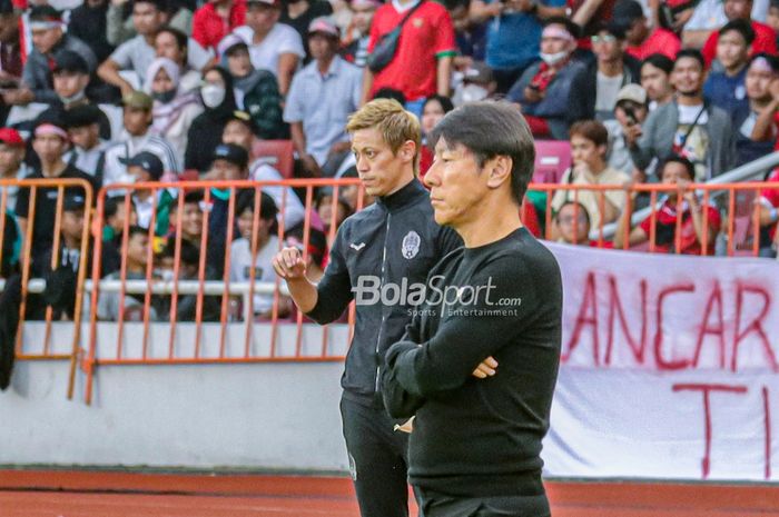 Manajer Timnas Kamboja, Keisuke Honda (kiri) dan Pelatih Timnas Indonesia, Shin Tae-yong (kanan), sedang memantau timnya bertanding dalam laga pekan pertama Grup A Piala AFF 2022 di Stadion Gelora Bung Karno, Senayan, Jakarta, 23 Desember 2022.
