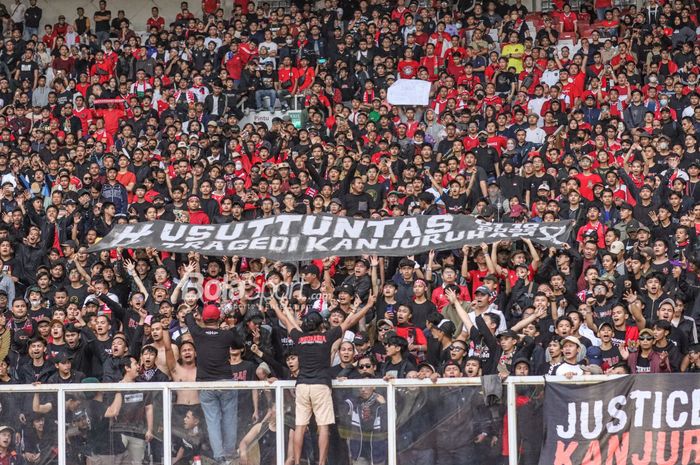 Suporter timnas Indonesia membentangkan spanduk terkait tragedi Kanjuruhan dalam laga pekan pertama Grup A Piala AFF 2022 di Stadion Gelora Bung Karno, Senayan, Jakarta, 23 Desember 2022.