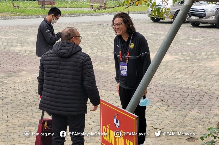 Pelatih timnas Malaysia, Kim Pan-gon, sedang berbincang dengan pelatih Vietnam, Park Hang-seo.