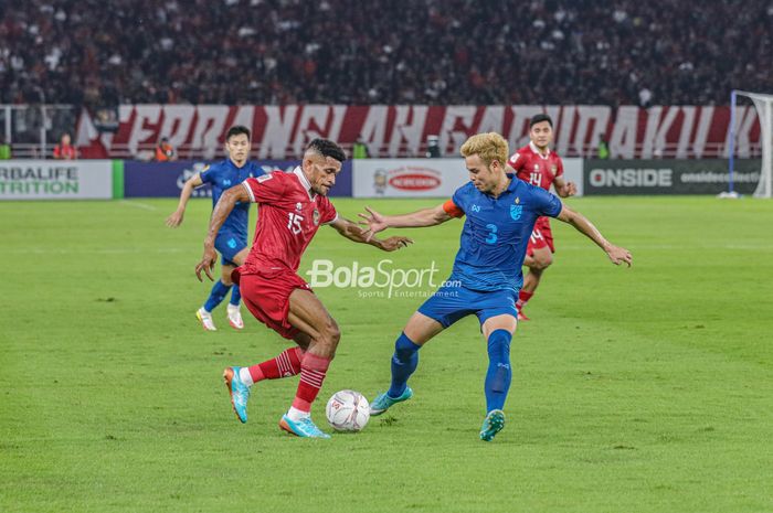 Gelandang timnas Indonesia, Ricky Kambuaya (kiri), sedang menguasai bola dan dijaga ketat oleh pemain timnas Thailand bernama Theerathon Bunmathan (kanan) dalam laga Piala AFF 2022 di Stadion Utama Gelora Bung Karno, Senayan, Jakarta, 29 Desember 2022.