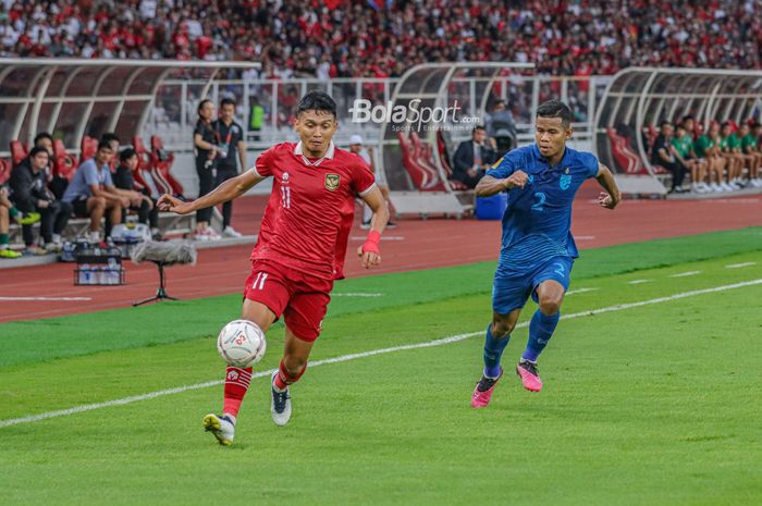 Striker timnas Indonesia, Dendy Sulistyawan (kiri), sedang menggiring bola dan dibayangi pemain timnas Thailand bernama Sasalak Haiprakhon (kanan) dalam laga Piala AFF 2022 di Stadion Utama Gelora Bung Karno, Senayan, Jakarta, 29 Desember 2022.