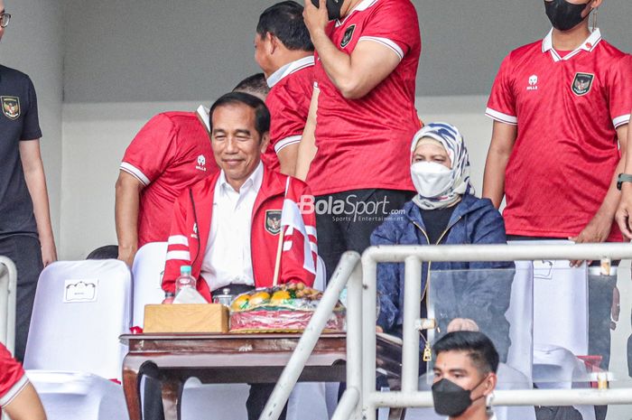 Presiden Republik Indonesia, Joko Widodo (kiri) alias Jokowi dan Ibu Negara Iriana Joko Widodo (kanan) tampak sedang tersenyum saat menonton timnas Indonesia berlaga pada Piala AFF 2022 di Stadion Utama Gelora Bung Karno, Senayan, Jakarta, 29 Desember 2022.