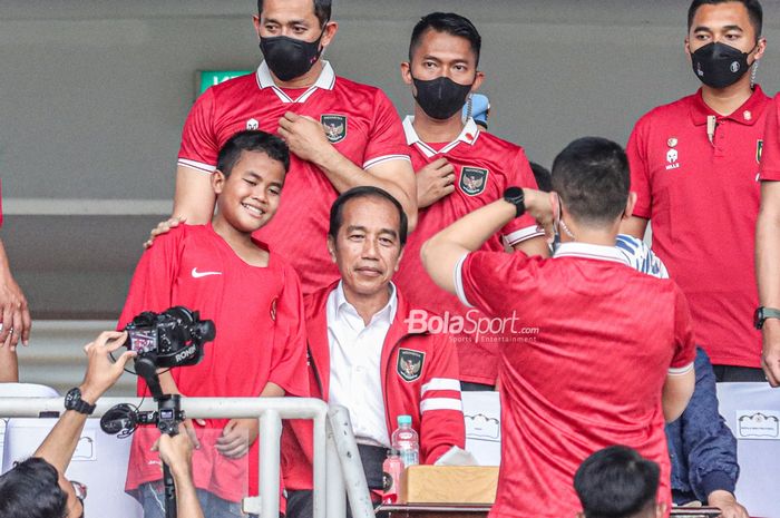Presiden Republik Indonesia, Joko Widodo alias Jokowi (tengah), sedang merangkul anak kecil saat menyaksikan laga timnas Indonesia pada Piala AFF 2022 di Stadion Utama Gelora Bung Karno, Senayan, Jakarta, 29 Desember 2022.