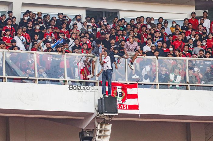 Aksi nekat oknum suporter timnas Indonesia yang berbahaya karena duduk di luar pagar tribun atas di Stadion Gelora Bung Karno, Senayan, Jakarta, 29 Desember 2022.