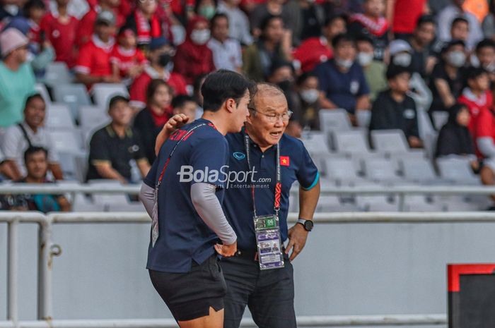 Pelatih timnas Vietnam, Park Hang-seo (kanan), tampak sedang berkomunikasi dengan asistennya saat memantau para pemainnya bertanding dalam laga leg pertama semifinal Piala AFF 2022 di Stadion Gelora Bung Karno, Senayan, Jakarta, 6 Januari 2023.