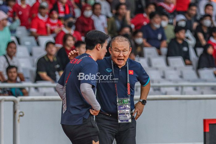 Pelatih timnas Vietnam, Park Hang-seo (kanan), tampak sedang berkomunikasi dengan asistennya saat memantau para pemainnya bertanding dalam laga leg pertama semifinal Piala AFF 2022 di Stadion Gelora Bung Karno, Senayan, Jakarta, 6 Januari 2023.