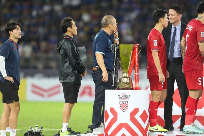 Pelatih timnas Vietnam, Park Hang-seo (tengah) melewati trofi Piala AFF 2022.
