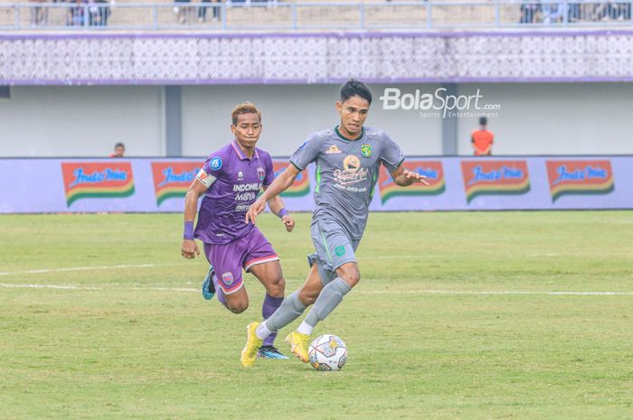 Gelandang Persebaya Surabaya, Marselino Ferdinan (kanan), sedang menggiring bola dan dibayangi bek Persita Tangerang bernama Muhammad Toha (kiri) dalam laga pekan ke-18 Liga 1 2022 di Stadion Indomilk Arena, Tangerang, Banteng, Rabu (18/1/2023).