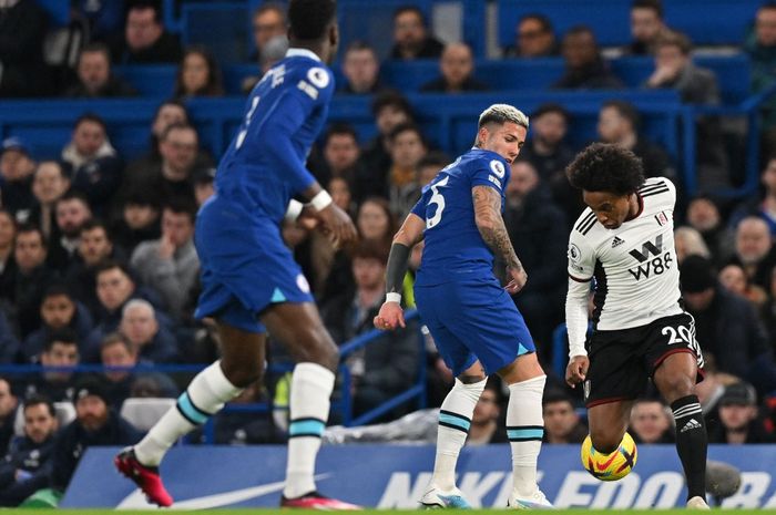 Gelandang Chelsea, Enzo Fernandez (Tengah), memperebutkan bola melawan gelandang Fulham, Willian,  selama pertandingan Liga Inggris 2022-2023 antara Chelsea dan Fulham di Stamford Bridge, Sabtu (4/2/2023) dini hari WIB. 
