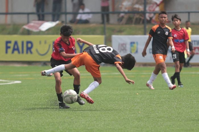 Pemain Villa 2000 (kanan) berebut bola dengan pemain Buperta Cibubur dalam Liga Fair Play U-14 Jabodetabek di Tehbotol Ayo Arena, Sentul, Bogor, Minggu (5/2/2023).