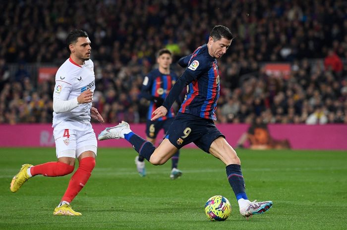 Robert Lewandowski (kanan) melepas tembakan dalam duel Barcelona vs Sevilla pada lanjutan Liga Spanyol di Spotify Camp Nou (5/2/2023).