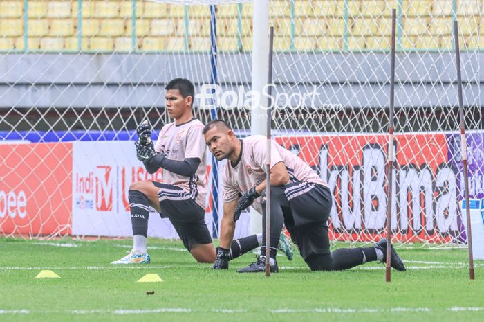 Dua kiper Persija Jakarta, Cahya Supriadi (kiri) dan Andritany Ardhiyasa (kanan), sedang melakukan pemanasan saat berlatih di Stadion Patriot Candrabhaga, Bekasi, Jawa Barat, Sabtu (11/2/2023) siang.