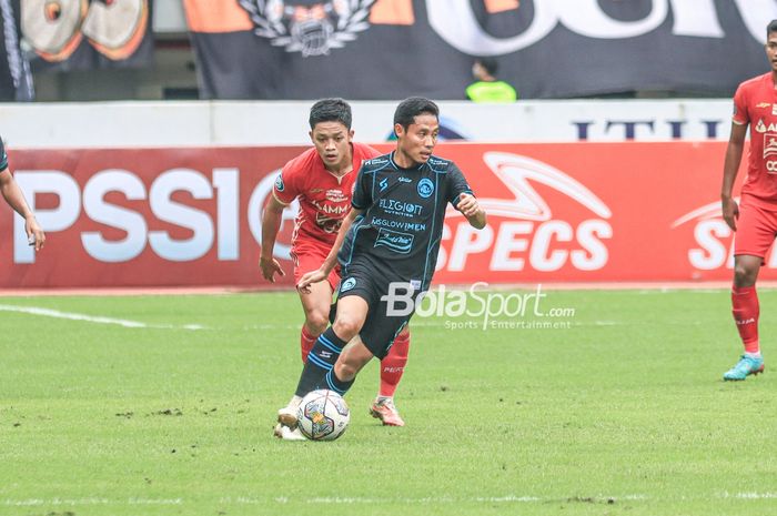 Gelandang Arema FC, Evan Dimas (depan), sedang menguasai bola dan dibayangi bek sayap kanan Persija Jakarta bernama Ilham Rio Fahmi (belakang) dalam laga pekan ke-24 Liga 1 2022 di Stadion Patriot Candrabhaga, Bekasi, Jawa Barat, 12 Februari 2023.