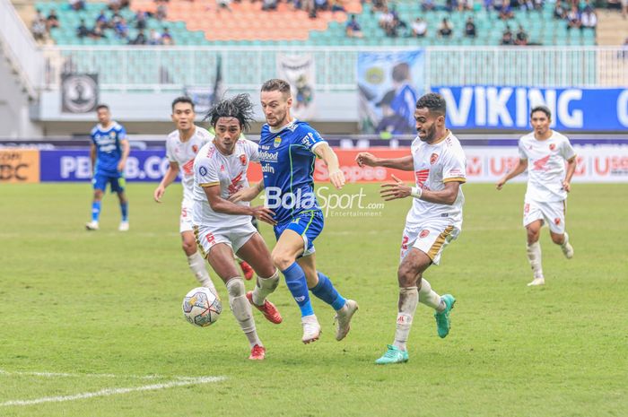 Gelandang Persib Bandung, Marc Klok (tengah), sedang berusaha melewati dua pemain PSM Makassar bernama Erwin Gutawa (kiri) dan Yakob Sayuri (kanan) dalam laga pekan ke-24 Liga 1 2022 di Stadion Pakansari, Bogor, Jawa Barat, Selasa (14/2/2023).