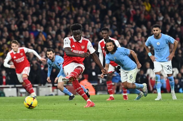 Winger Arsenal, Bukayo Saka, mencetak gol penalti ke gawang Manchester City pada laga tunda pekan ke-12 Liga Inggris 2022-2023 di Emirates Stadium, Rabu (15/2/2023).