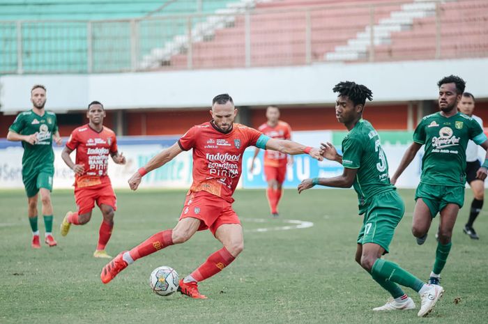 Pemain Bali United, Ilija Spasojevic berduel dengan bek Persebaya, Alta Ballah dalam laga lanjutan Liga 1 2022/2023.