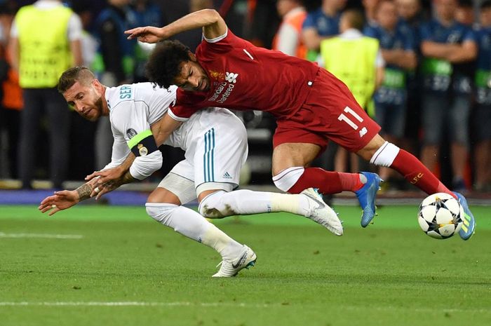 Momen Mohamed Salah dijatuhkan Sergio Ramos pada duel Liverpool vs Real Madrid di final Liga Champions di Kiev (26/5/2018). Kini Mo Salah kembali bertemu Madrid sebagai musuh paling buas.