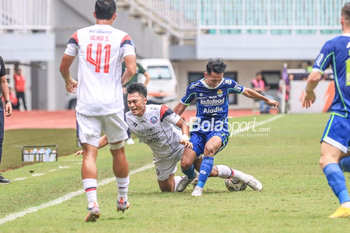 Gelandang Arema FC, Rizky Dwi Febrianto (kiri), sedang dijatuhkan oleh pemain Persib Bandung bernama Beckham Putra Nugraha (kanan) dalam laga pekan ke-26 Liga 1 2022 di Stadion Pakansari, Bogor, Jawa Barat, Kamis (23/2/2023).