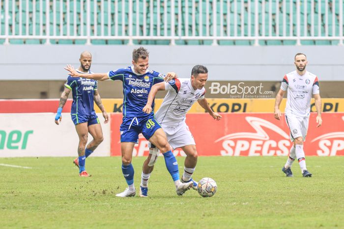 Bek sayap kiri Persib Bandung, Rezaldi Hehanussa (kiri), sedang merebut bola yang dikuasai pemain Arema FC bernama Dendi Santoso (kanan) dalam laga pekan ke-26 Liga 1 2022 di Stadion Pakansari, Bogor, Jawa Barat, Kamis (23/2/2023).