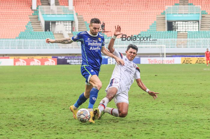 Gelandang Persib Bandung, Marc Klok, sedang mengusai bola dan berusaha ditekel striker Arema FC bernama Dedik Setiawan (kanan) dalam laga pekan ke-26 Liga 1 2022 di Stadion Pakansari, Bogor, Jawa Barat, Kamis (23/2/2023).