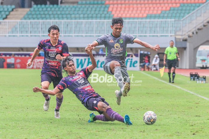 Pemain RANS Nusantara FC, Ady Setiawan (tengah), sedang menekel bola yang dikuasai oleh pilar Persebaya Surabaya bernama Arief Catur Pamungkas (kanan) dalam laga pekan ke-27 Liga 1 2022 di Stadion Pakansari, Bogor, Jawa Barat, Selasa (28/2/2023).